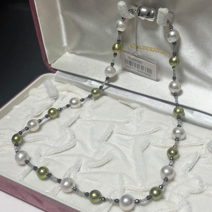 Akoya pearl necklace with pistachio dye pearls and silver findings on a white background
