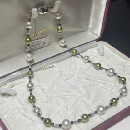 Akoya pearl necklace with pistachio dye pearls and silver findings on a white background