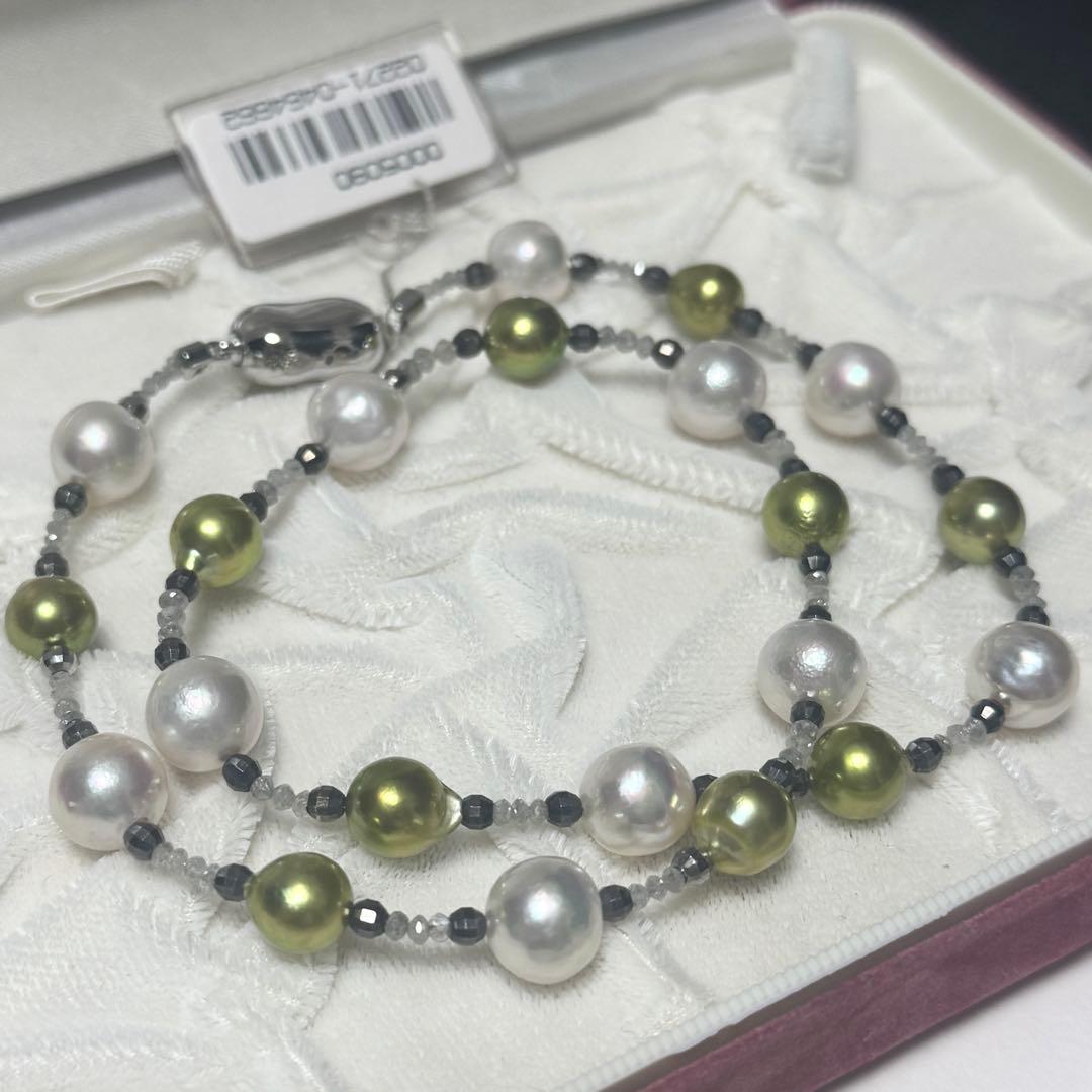 Akoya pearl necklace with pistachio dye pearls and silver findings on a white background