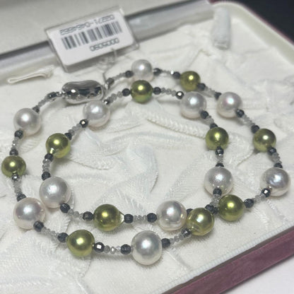 Akoya pearl necklace with pistachio dye pearls and silver findings on a white background