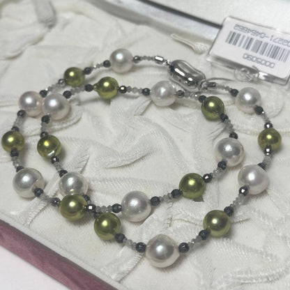 Akoya pearl necklace with pistachio dye pearls and silver findings on a white background