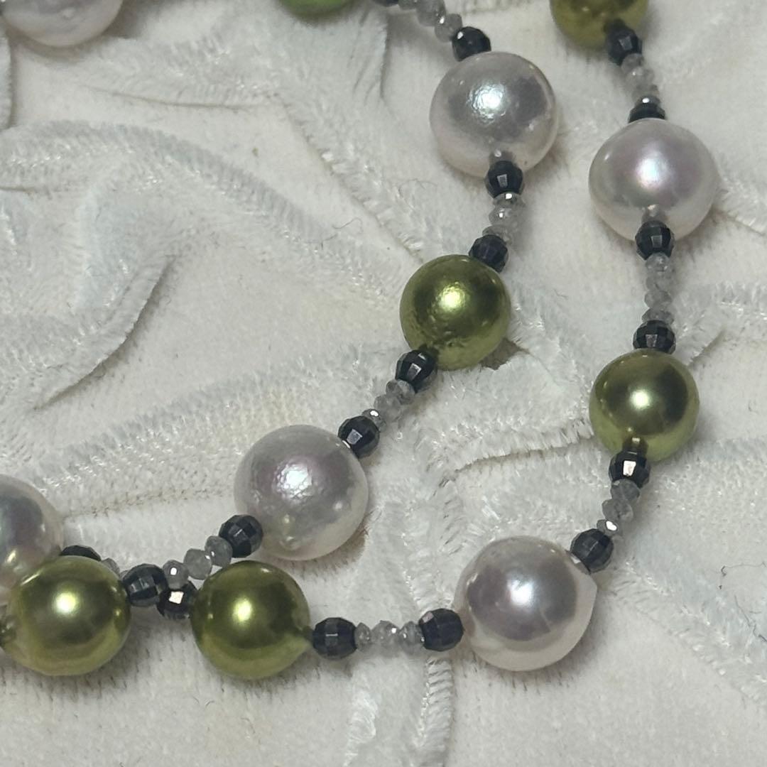 Akoya pearl necklace with pistachio dye pearls and silver findings on a white background