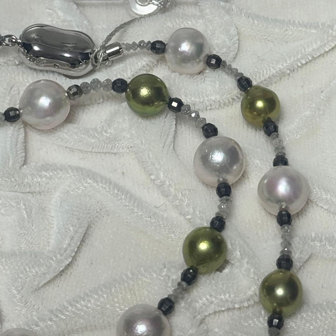 Akoya pearl necklace with pistachio dye pearls and silver findings on a white background