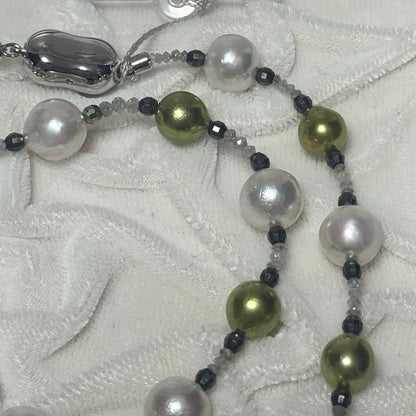 Akoya pearl necklace with pistachio dye pearls and silver findings on a white background