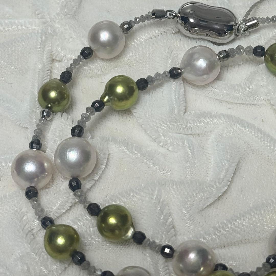 Akoya pearl necklace with pistachio dye pearls and silver findings on a white background