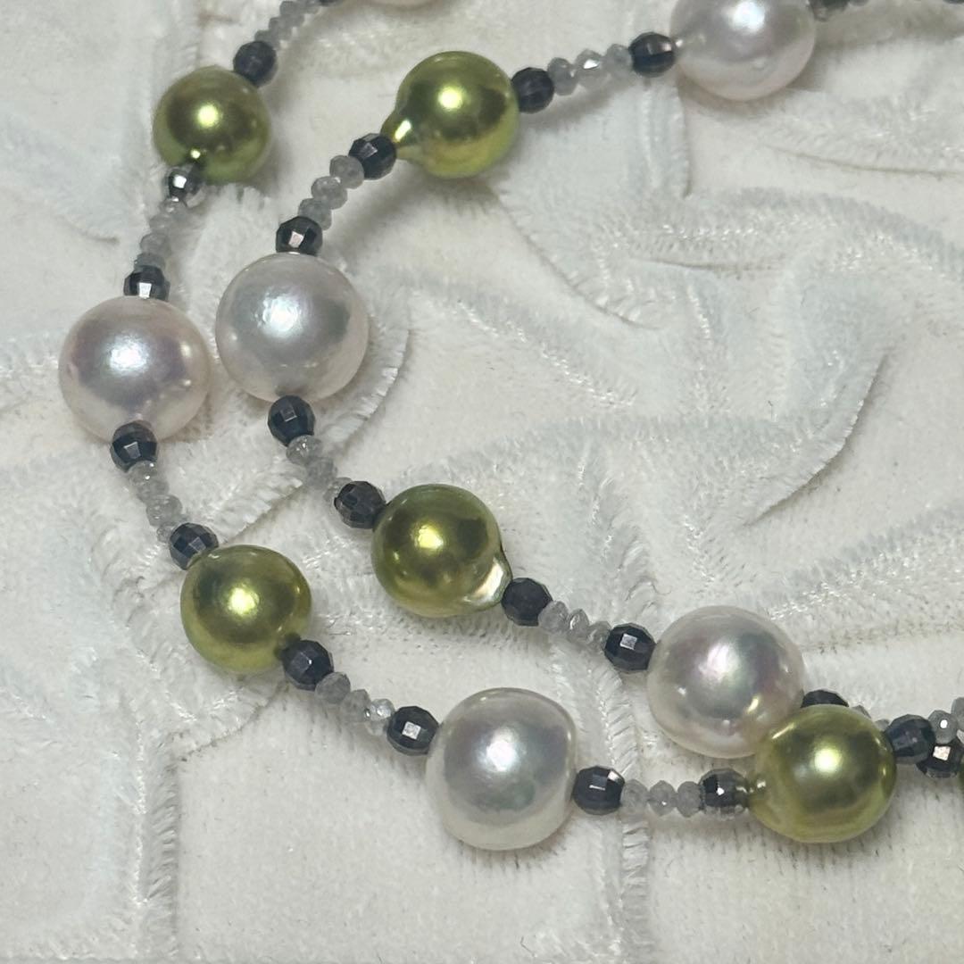 Akoya pearl necklace with pistachio dye pearls and silver findings on a white background