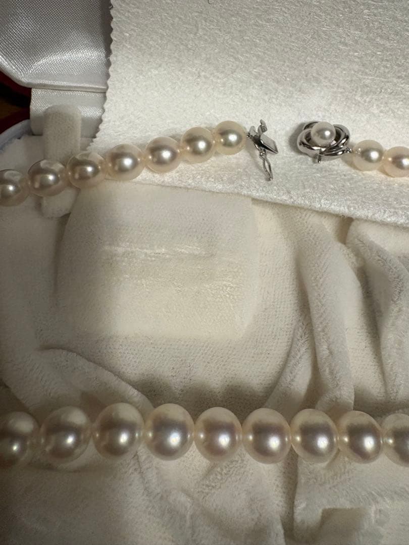 Tasaki Akoya pearl necklace with 8mm pearls and silver fittings laid out flat
