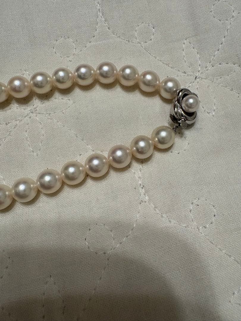 Tasaki Akoya pearl necklace with 8mm pearls and silver fittings laid out flat