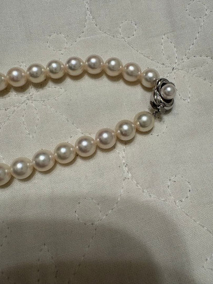 Tasaki Akoya pearl necklace with 8mm pearls and silver fittings laid out flat