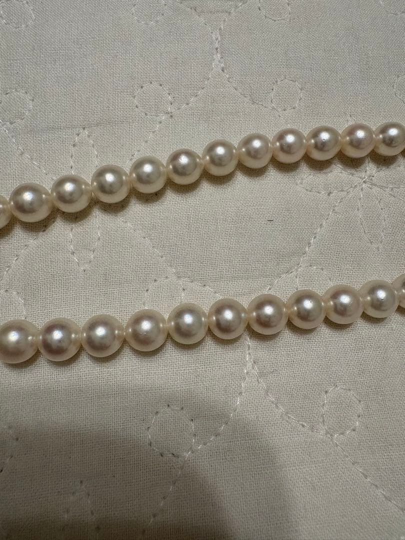 Tasaki Akoya pearl necklace with 8mm pearls and silver fittings laid out flat