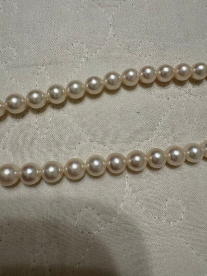 Tasaki Akoya pearl necklace with 8mm pearls and silver fittings laid out flat