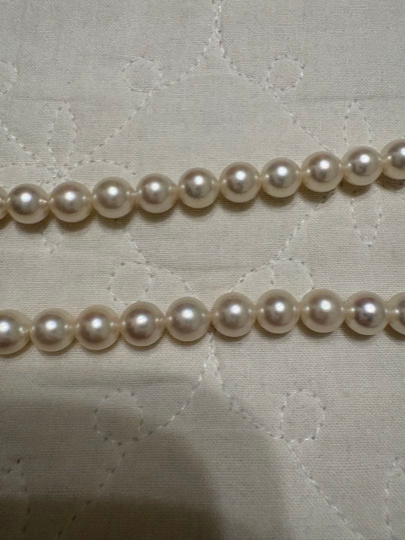 Tasaki Akoya pearl necklace with 8mm pearls and silver fittings laid out flat