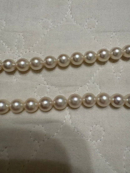 Tasaki Akoya pearl necklace with 8mm pearls and silver fittings laid out flat