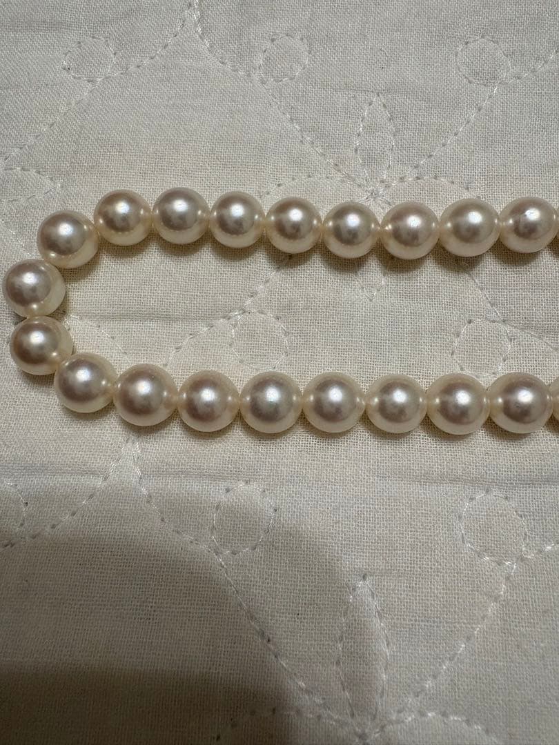 Tasaki Akoya pearl necklace with 8mm pearls and silver fittings laid out flat