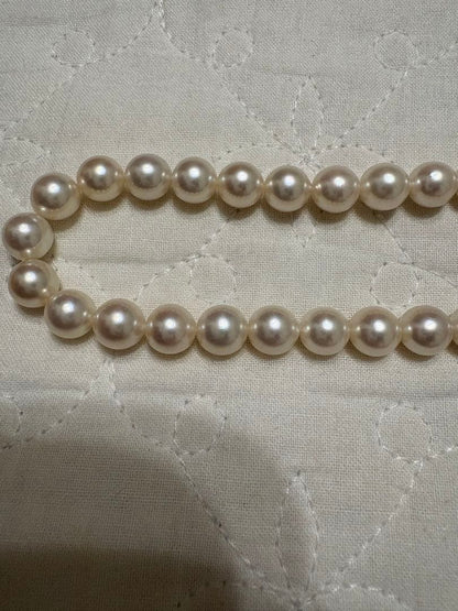 Tasaki Akoya pearl necklace with 8mm pearls and silver fittings laid out flat