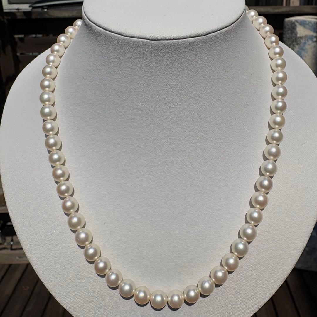 Tasaki Akoya pearl necklace with 8mm pearls and silver fittings laid out flat