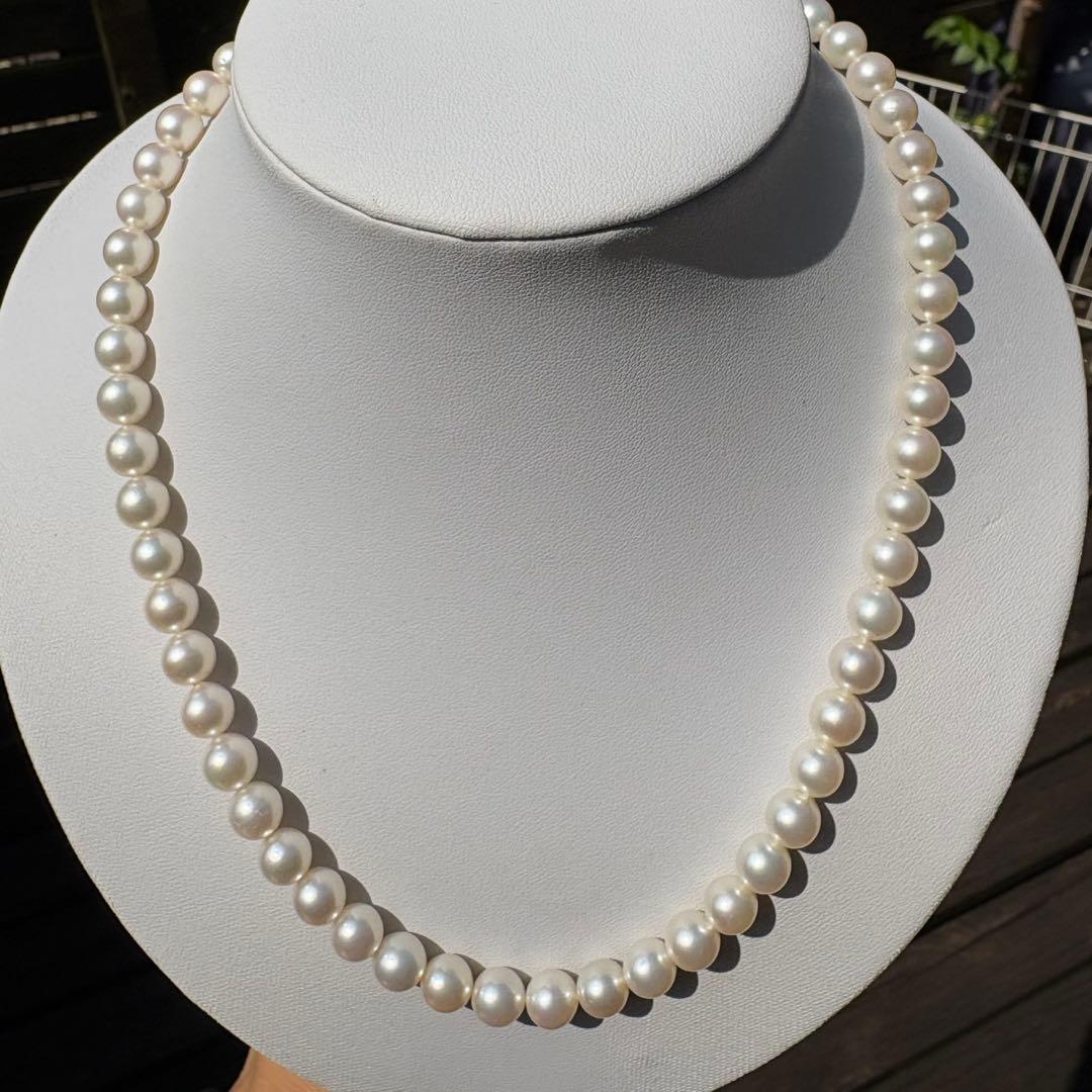 Tasaki Akoya pearl necklace with 8mm pearls and silver fittings laid out flat