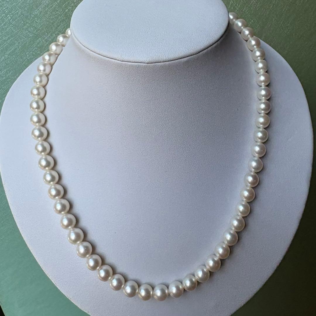 Tasaki Akoya pearl necklace with 8mm pearls and silver fittings laid out flat