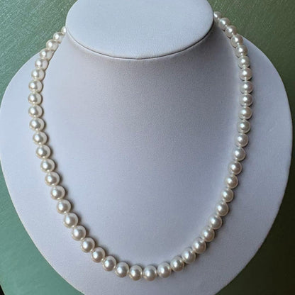Tasaki Akoya pearl necklace with 8mm pearls and silver fittings laid out flat