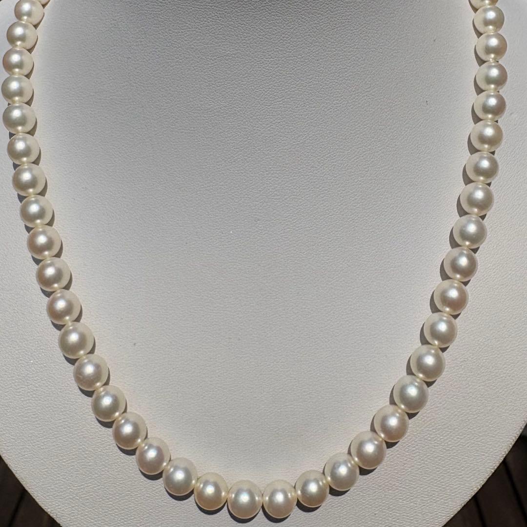 Tasaki Akoya pearl necklace with 8mm pearls and silver fittings laid out flat
