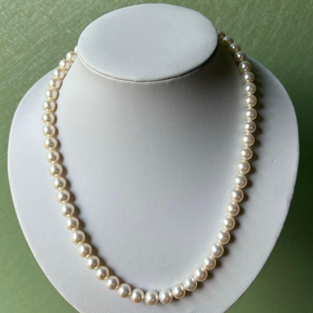 Tasaki Akoya pearl necklace with 8mm pearls and silver fittings laid out flat