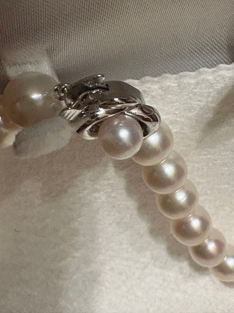 Tasaki Akoya pearl necklace with 8mm pearls and silver fittings laid out flat