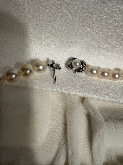 Tasaki Akoya pearl necklace with 8mm pearls and silver fittings laid out flat