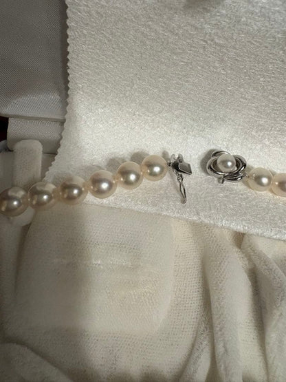 Tasaki Akoya pearl necklace with 8mm pearls and silver fittings laid out flat