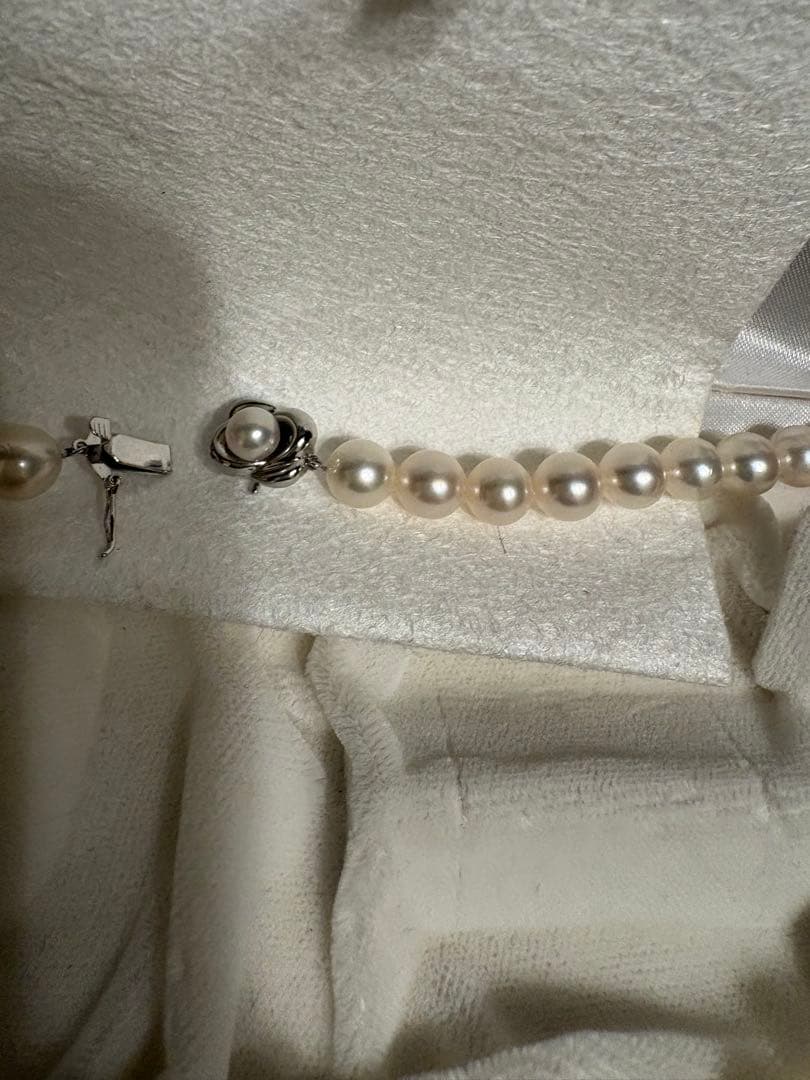 Tasaki Akoya pearl necklace with 8mm pearls and silver fittings laid out flat
