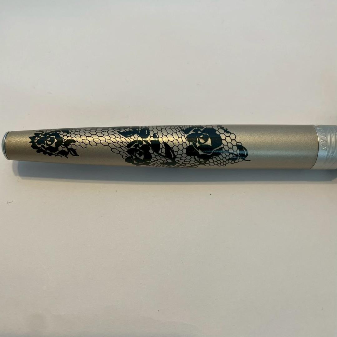 Waterman Audace ballpoint pen with a rose pattern cap, displayed uncapped showing its sleek design