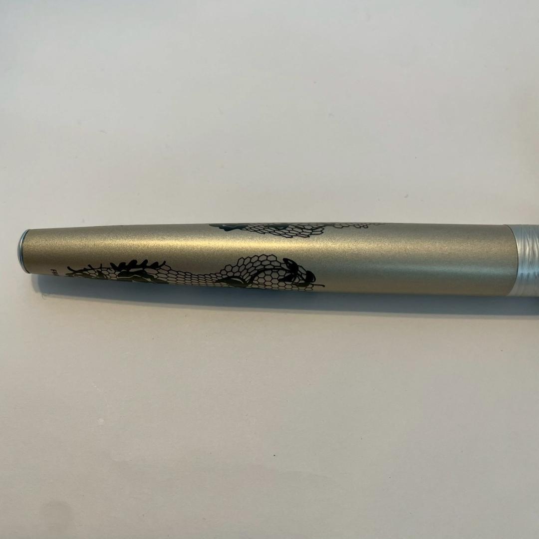 Waterman Audace ballpoint pen with a rose pattern cap, displayed uncapped showing its sleek design
