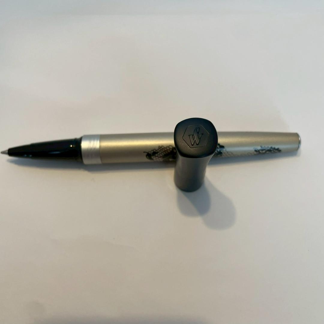 Waterman Audace ballpoint pen with a rose pattern cap, displayed uncapped showing its sleek design