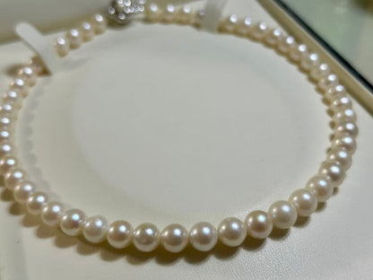 Close-up of Akoya pearl necklace with 8.4mm pearls measuring 42cm in length on a white background