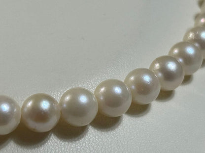 Close-up of Akoya pearl necklace with 8.4mm pearls measuring 42cm in length on a white background