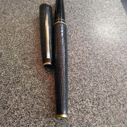 Pilot fountain pen with 18K gold fine nib and brown leather wrapped body on white background