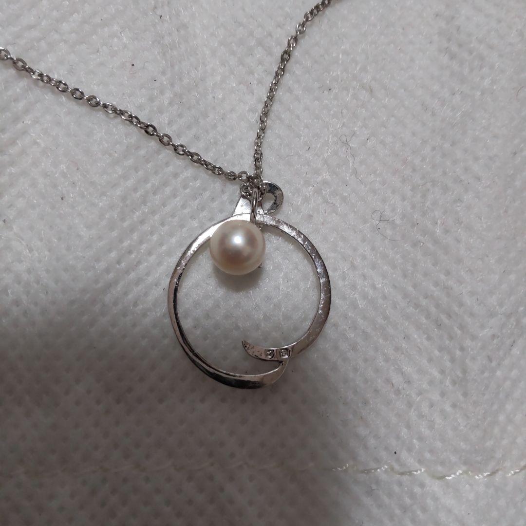 Elegant Mikimoto pearl necklace with gold chain on white background
