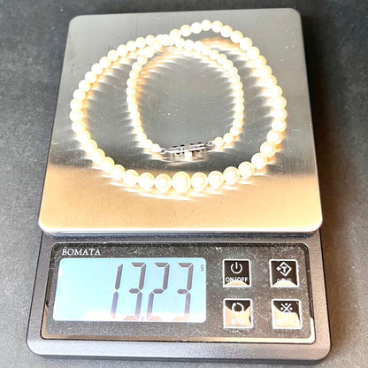 MIKIMOTO Graduation Necklace with cultured pearls and silver clasp on white background
