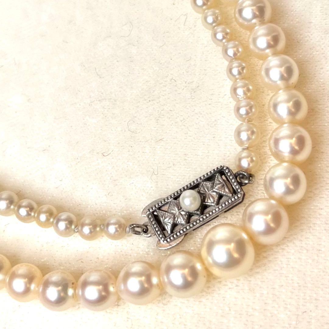 MIKIMOTO Graduation Necklace with cultured pearls and silver clasp on white background