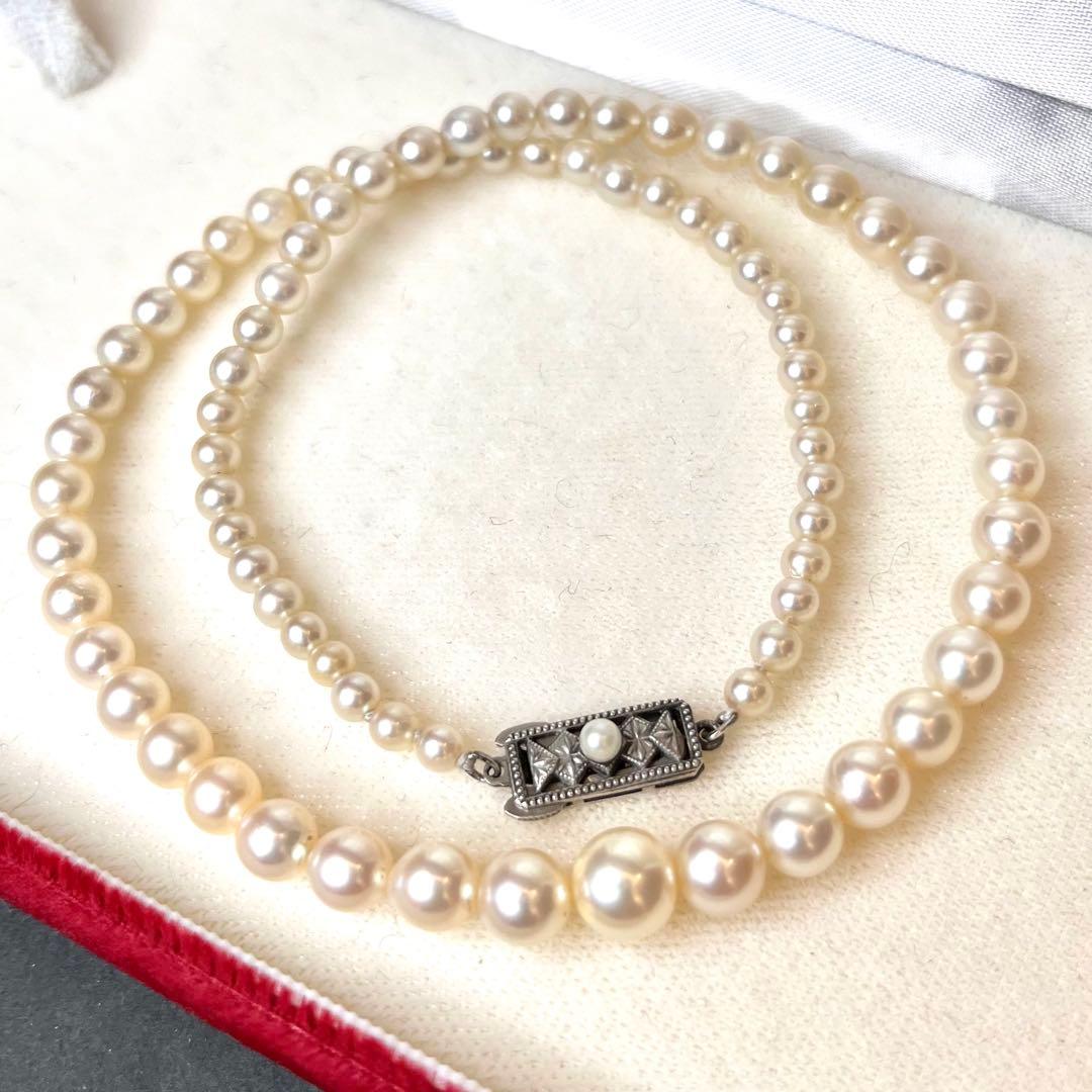 MIKIMOTO Graduation Necklace with cultured pearls and silver clasp on white background