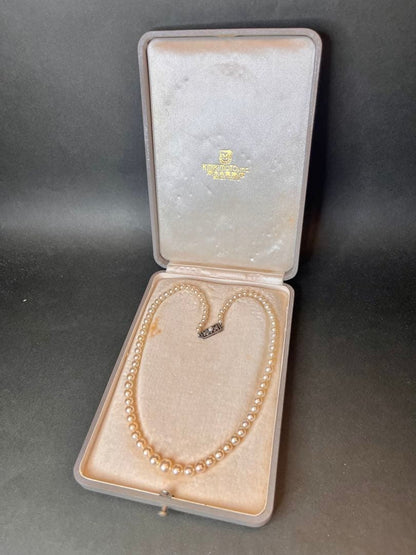 MIKIMOTO Graduation Necklace with cultured pearls and silver clasp on white background