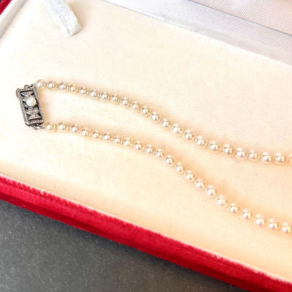 MIKIMOTO Graduation Necklace with cultured pearls and silver clasp on white background