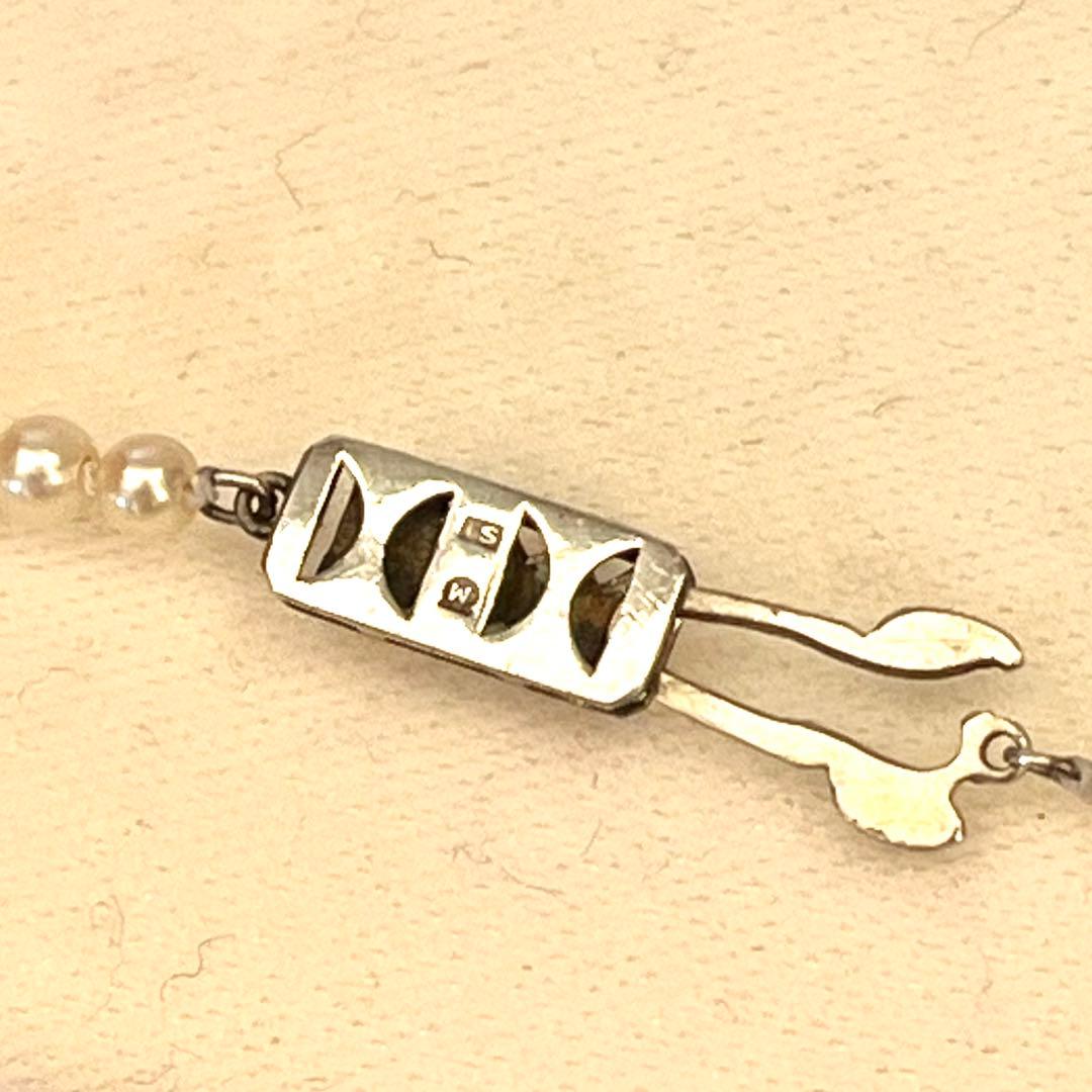 MIKIMOTO Graduation Necklace with cultured pearls and silver clasp on white background