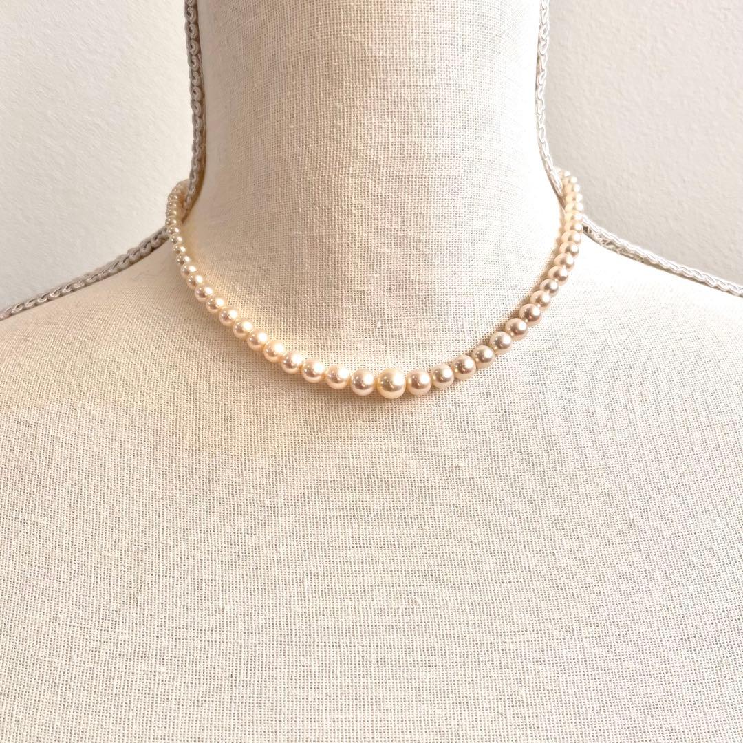 MIKIMOTO Graduation Necklace with cultured pearls and silver clasp on white background