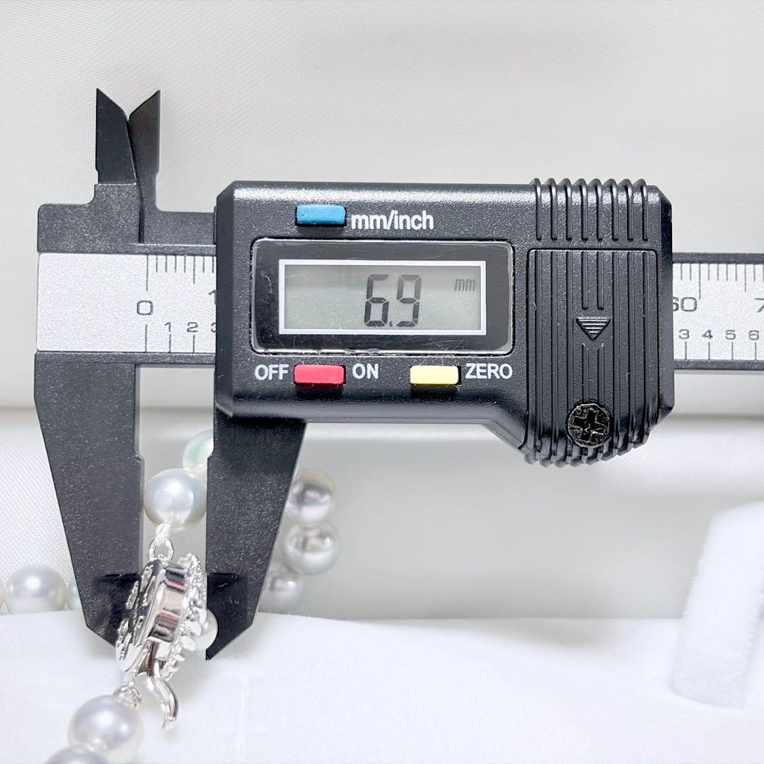 Akoya pearl necklace with 6.9-7.5mm light gray pearls and silver clasp on a white background