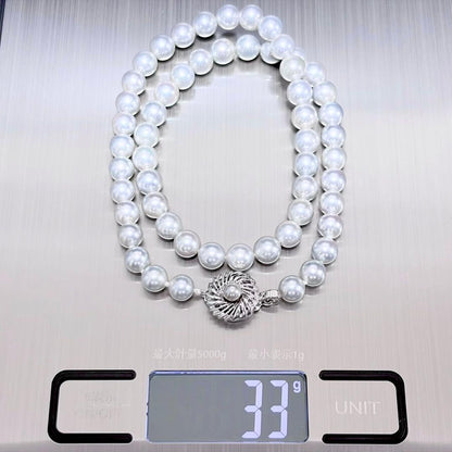 Akoya pearl necklace with 6.9-7.5mm light gray pearls and silver clasp on a white background