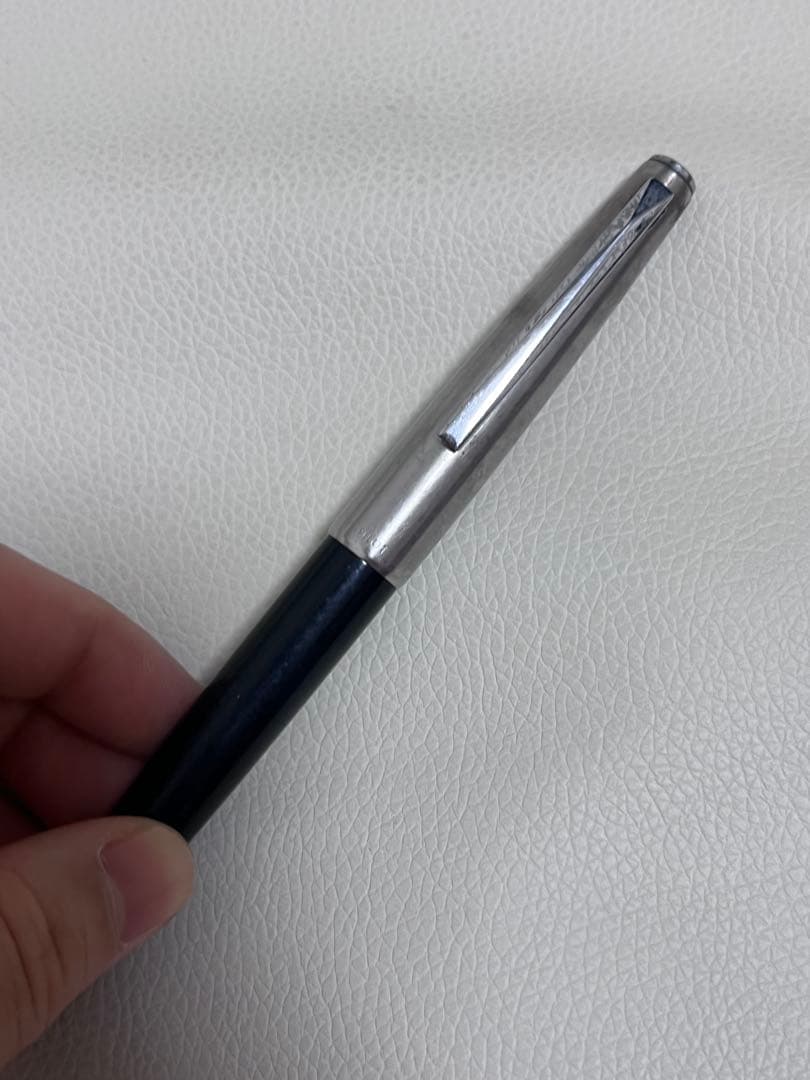 14K pen tip PILOT fountain pen with black and silver body and inset nib on white background