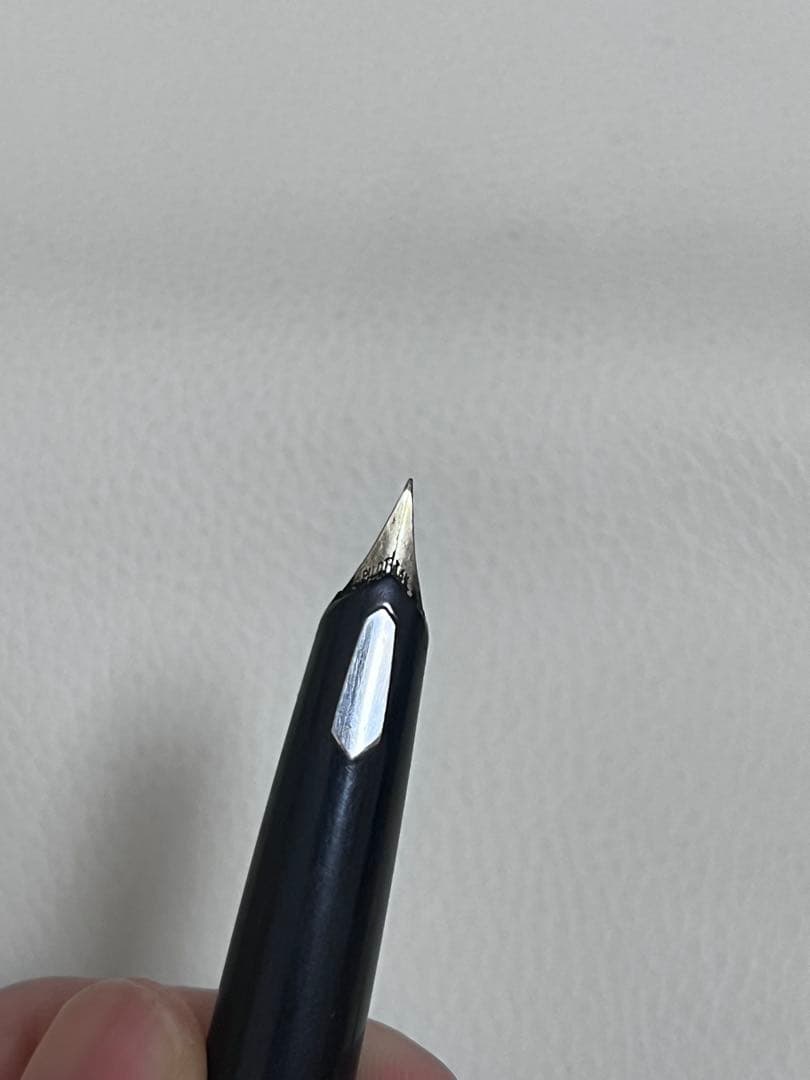 14K pen tip PILOT fountain pen with black and silver body and inset nib on white background