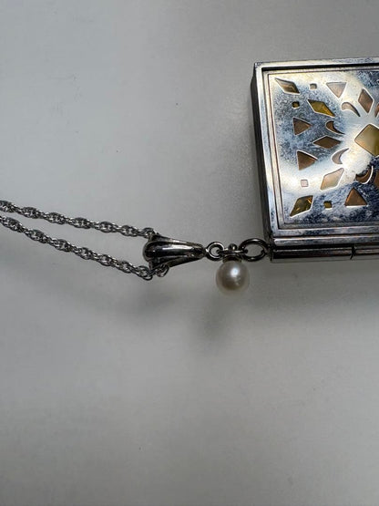 Mikimoto pearl necklace with decorative silver geometric pendant and removable rocket-shaped charm on adjustable chain