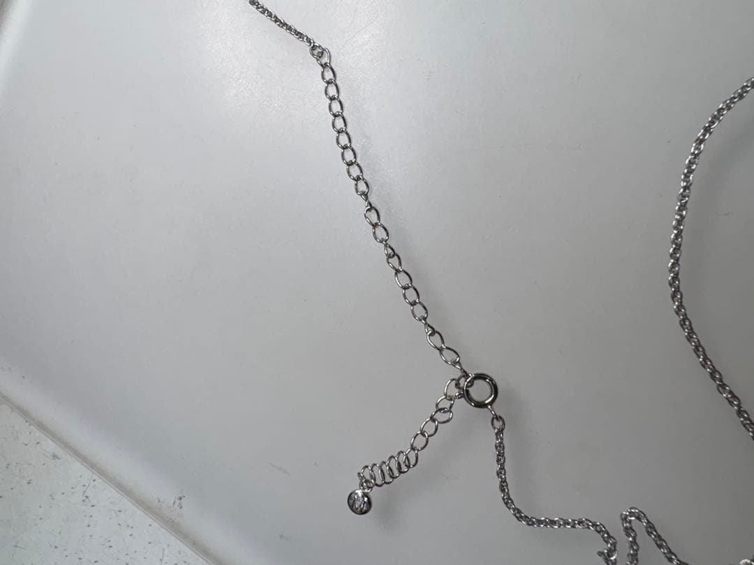 Mikimoto pearl necklace with decorative silver geometric pendant and removable rocket-shaped charm on adjustable chain