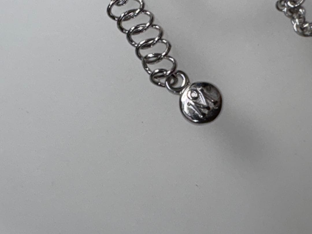 Mikimoto pearl necklace with decorative silver geometric pendant and removable rocket-shaped charm on adjustable chain